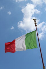 Italian flag in cloudy sky. waving in the sky. Italian flag in a wind on a cloudy blue sky background in Rome