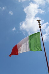 Italian flag in cloudy sky. waving in the sky. Italian flag in a wind on a cloudy blue sky background in Rome