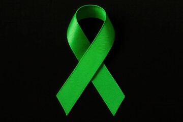 A green awareness ribbon on a black background