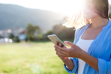 Young woman using mobile phone outdoors. Technology lifestyle. People virtual connection,...