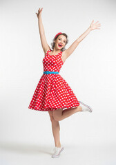Naklejka premium Excited retro woman jumping in polka dot dress