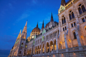 Obraz premium A night view of the Danube side facade of the beautifully illuminated House of Parliament in Budapest, Hungary