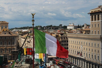 Italian flag waving in wind with Rome in Background 