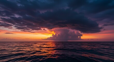 Fototapeta premium Dramatic Ocean Sunset with Imposing Dark Cloudscape