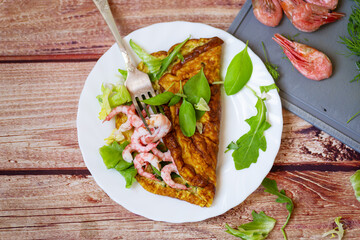 Appetizing breakfast omelette with shrimps and dill