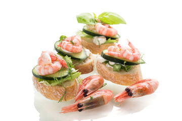 Appetizing appetizers with shrimps, sauce and cucumbers on a white background