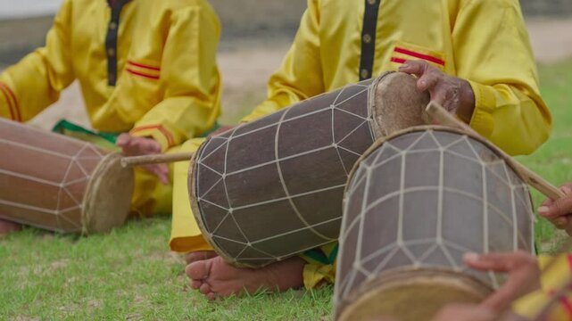 A traditional percussionist plays Indonesian ethnic music. A musician plays a traditional Indonesian musical instrument known as a kendang or gendang