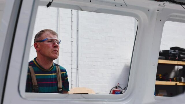 Auto Body Repair Technician Working on Van Windows Frame at Workshop