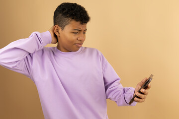 Young brown skinned Latino man wearing a lilac sweatshirt with a disgusted expression when seeing...