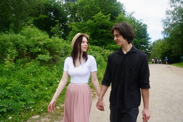 A man and a woman are walking together in a park