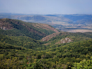 Forest-covered slopes and distant hills viewed from the cliffs of Látó-kövek in Hungary’s...