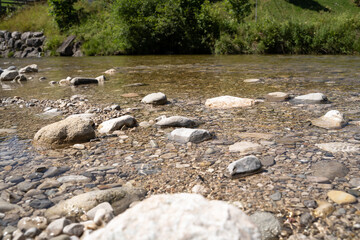 Clear mountain stream with pebbles and rocks in summer