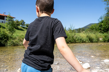 Boy throw stones into the river 