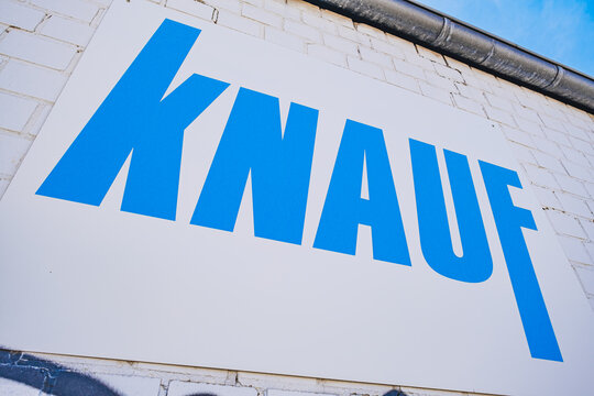 Knauf building materials company's logo on the white brick wall