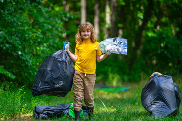 Kid with bin bag full of waste and trash tongs during garbage collection. Cute child with recycle bin collecting plastic waste in forest or park. Eco activists. Environmental conservation and ecology.