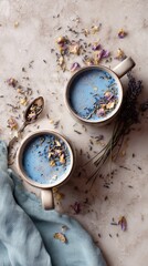 Two Cups of Lavender Blue Latte With Dried Flowers and a Spoon on a Marble Surface