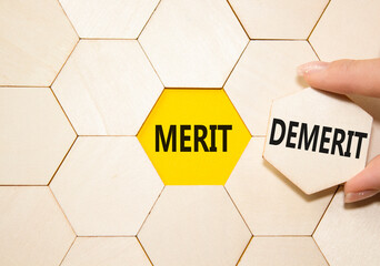 Merit or Demerit symbol. Concept word Merit or Demerit on wooden comb puzzle. Businessman hand....