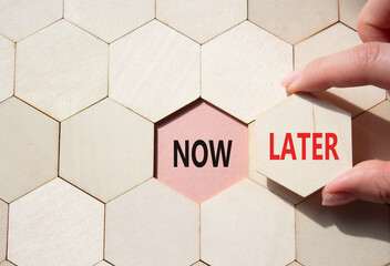 Now vs Later symbol. Concept word Now vs Later on wooden comb puzzle. Businessman hand. Beautiful...
