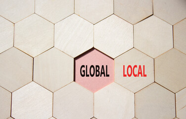 Global and Local symbol. Concept word Global and Local on wooden comb puzzle. Beautiful pink...
