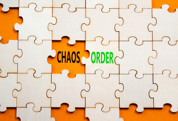 Chaos or Order symbol. Concept word Chaos or Order on wooden puzzle. Beautiful orange background....