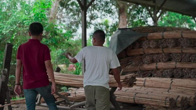 Two workers walk in a rattan processing factory
