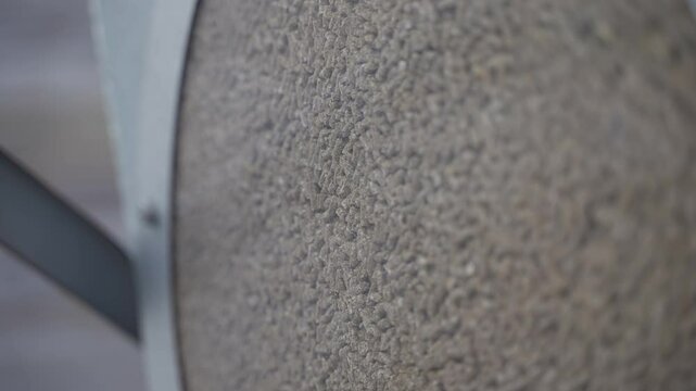 A clear view of dry cattle feed pellets visible through the transparent hatch of a steel feed container. This close-up highlights the texture and uniform size of feed used in automated feeding systems