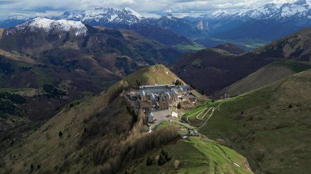 Panoramic view of the Basilica of Our Lady of La Salette in the French Alps, surrounded by lush forests and snow-covered mountains. Site of the 1846 Marian apparitions.