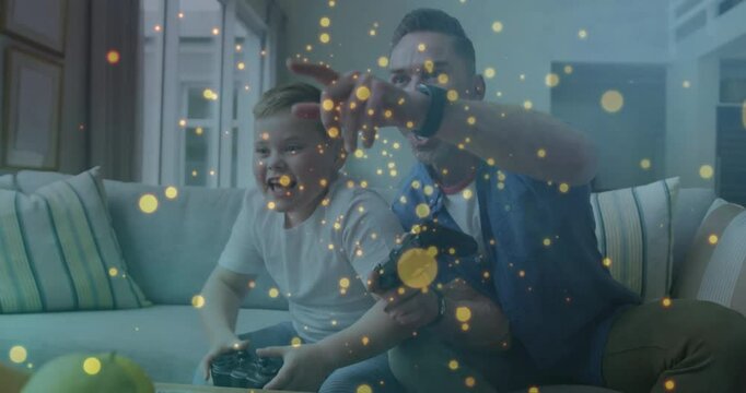 Father and son pressing gaming controller on sofa, celebrating win with golden particles swirling