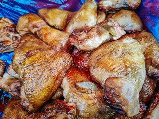 Close-up of golden brown smoked chicken thighs stacked on a blue-lined surface, showcasing their crispy texture and juicy appearance. Rustic and appetizing.