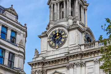 St Pauls Cathedral clock tower in London against clear blue summer sky, baroque stone