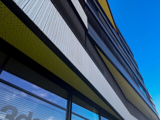 Modern architectural building facade with geometric patterns and vibrant colors against blue sky