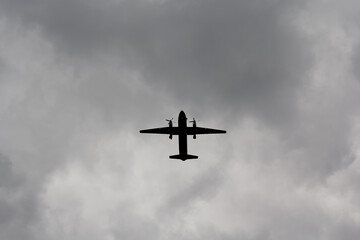 The silhouette of the aircraft against the backdrop of a cloudy sky