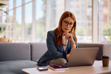 Female CEO working on laptop in the office.