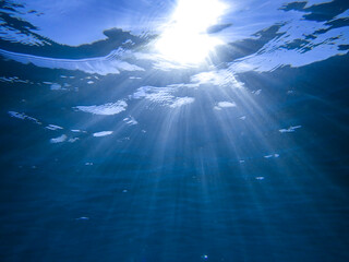 Light filtering down through blue water. Underwater sunlight in deep sea. Light viewed from blue...