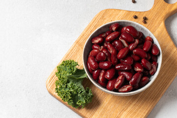 Canned red beans in bowl on wooden board. Vegetarian and healthy food concept.