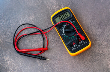 A digital multimeter with wires for measuring voltage.A device for ringing wires.A home multimeter.