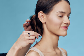 A young woman of Asian descent with a serene expression, wearing a light outfit, having her hair...