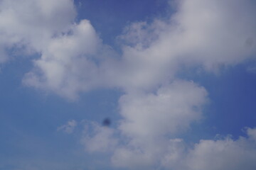 Blue Sky with Fluffy Clouds and a Dark, Mysterious Shadow