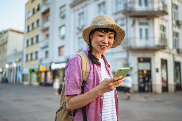 japanese woman use mobile phone walk with suitcase and touring city