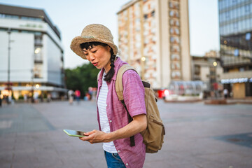 japanese woman use mobile phone walk with suitcase and touring city