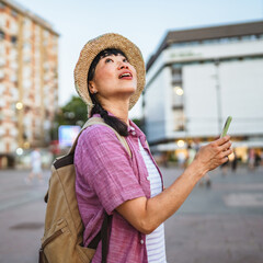 japanese woman use mobile phone walk with suitcase and touring city