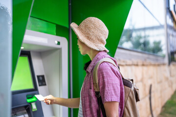 woman use credit card and withdrawing cash at the ATM outdoor