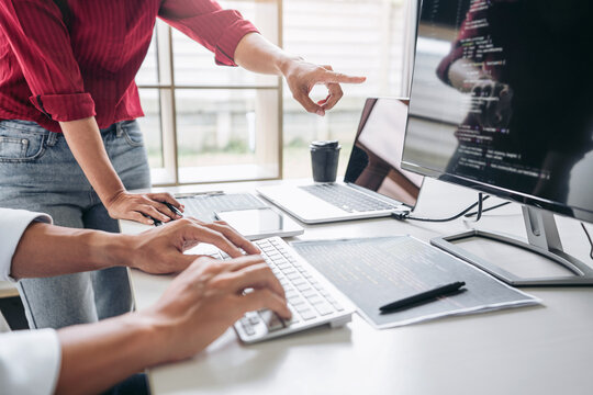 Two professional programmer cooperating and working on web site project in a software developing on desktop computer at company, codes and typing data code, Programming with HTML, PHP and javascript