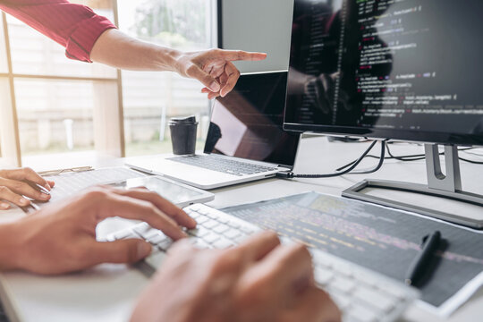 Two professional programmer cooperating and working on web site project in a software developing on desktop computer at company, codes and typing data code, Programming with HTML, PHP and javascript