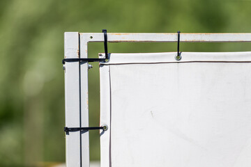 white outdoor banner attached to metal frame with black zip ties closeup advertising sign...