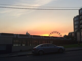 Urban sunset in the city with ferris wheel in the distance