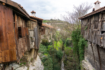 Old wooden Ottoman houses in Safranbolu, Turkey, built over a narrow green valley with stone bases...