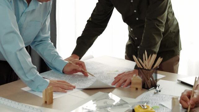 Professional engineer measuring the blueprint. Professional engineer working architectural project at studio on a table with yellow helmet and architectural equipment scatter around. Delineation.