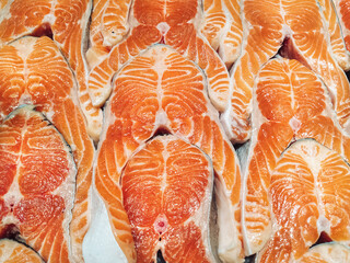Pieces of fresh salmon or trout lie next to each other. Background of red fatty fish.