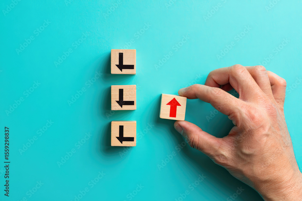 Poster hand placing a wooden block with an upward arrow among blocks with downward arrows on a blue backgro